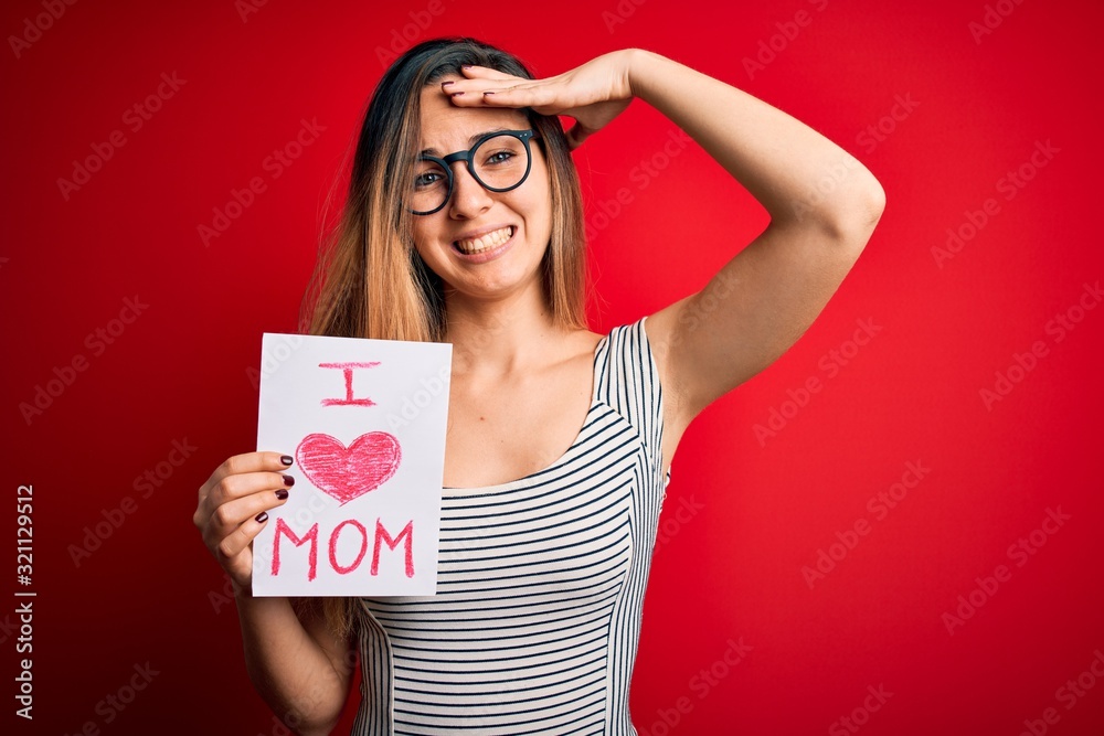 Young beautiful woman holding paper with love mom message celebrating mothers day stressed with hand on head, shocked with shame and surprise face, angry and frustrated. Fear and upset for mistake. Young beautiful woman holding paper with love mom message celebrating mothers day stressed with hand on head, shocked with shame and surprise face, angry and frustrated. Fear and upset for mistake.