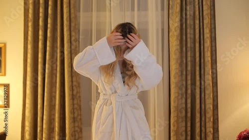 A girl in a bathrobe at a photoshoot poses for the photographer photo