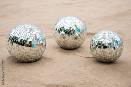 Disco ball on sand, view from above. Beach party