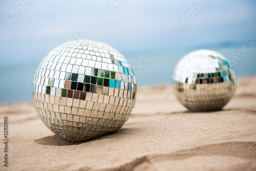 Disco ball on sand  view from above. Beach party