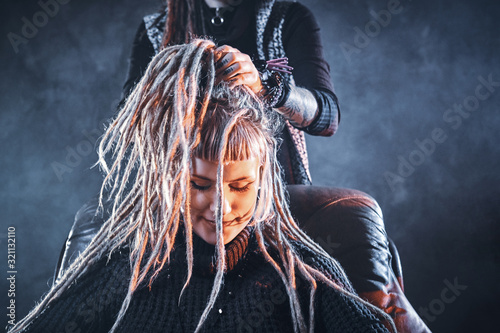 Fotomural Young pensive woman got new freaky hairstyle from dreadlocks master