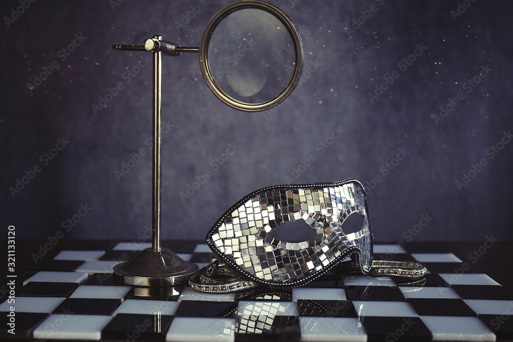 Maschera d'argento sopra la scacchiera bianca e nera ,la festa dei coriandoli e cristalli Maschera d'argento sopra la scacchiera bianca e nera ,la festa dei coriandoli e cristalli