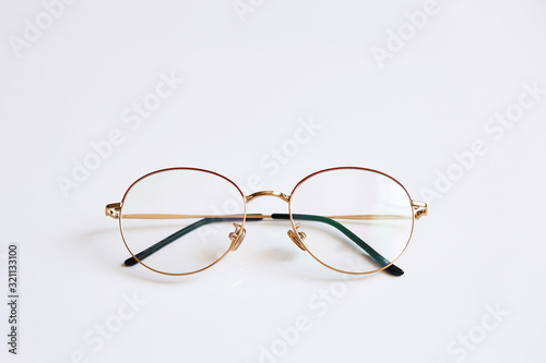 Rounded vintage glasses isolated on white background. Advertising photo of rounded metal eyewear with shadow. Fashion optical concept. Only retro glasses at white background