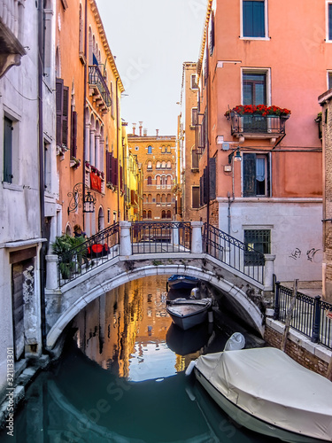 Bridge over a small canal in Venice with the evening sun reflecting in the water, Venice, Italy © MiriamGimbel