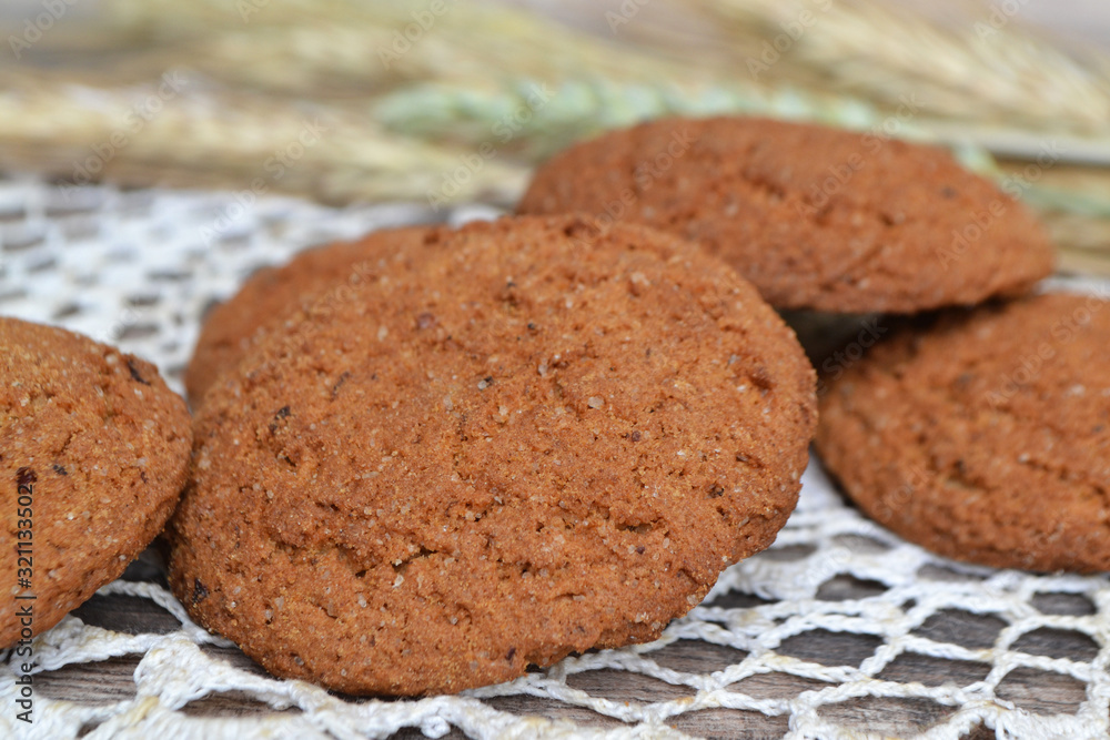 fresh crispy cereal cookies and ears on knitted napkin and rustic wooden table fresh crispy cereal cookies and ears on knitted napkin and rustic wooden table
