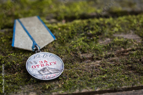 The Old Soviet Medal - For Bravery of the Second World War on natural moss background, Victory Day May 9 photo