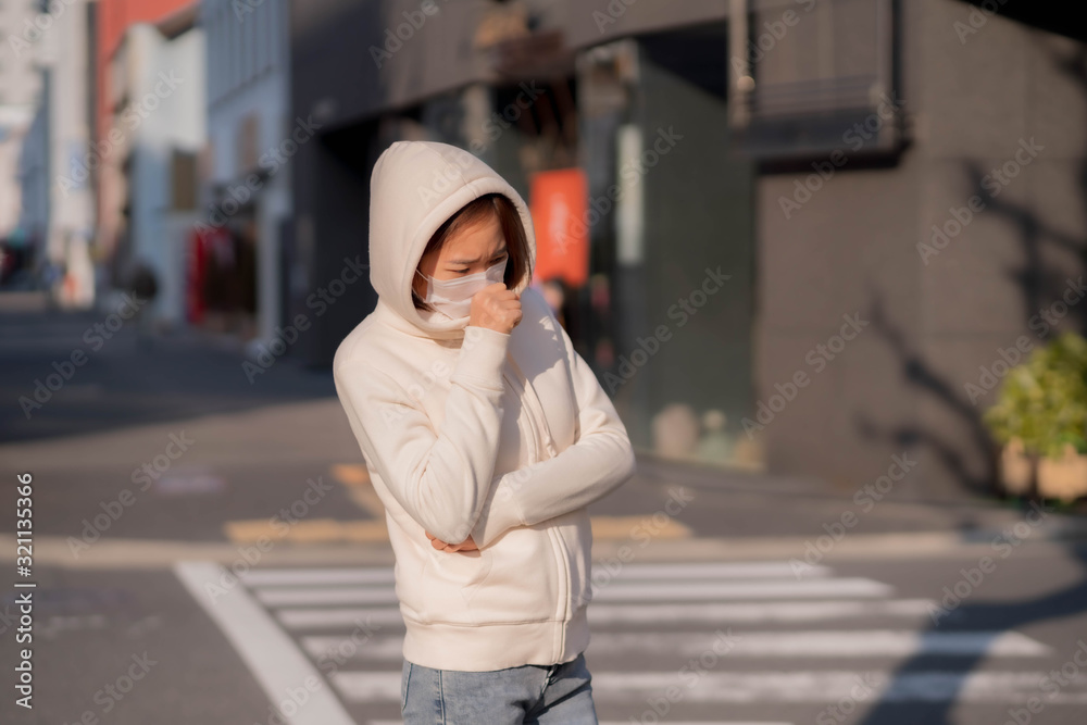 Fototapeta premium 屋外でマスクをしている若い女性