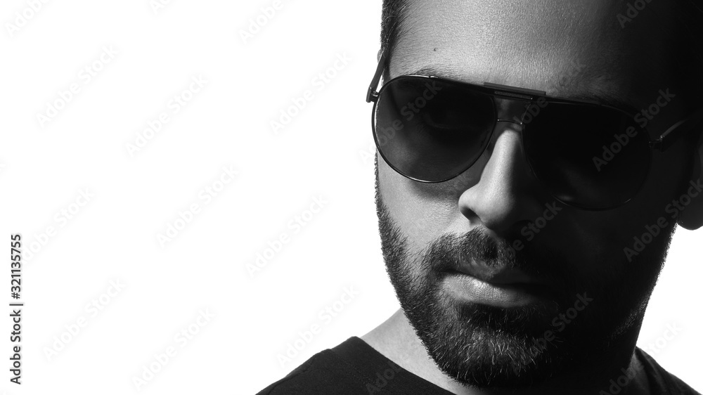 Fototapeta premium Black and white Head shot of Arab man wearing sunglasses isolated on white background with copy space