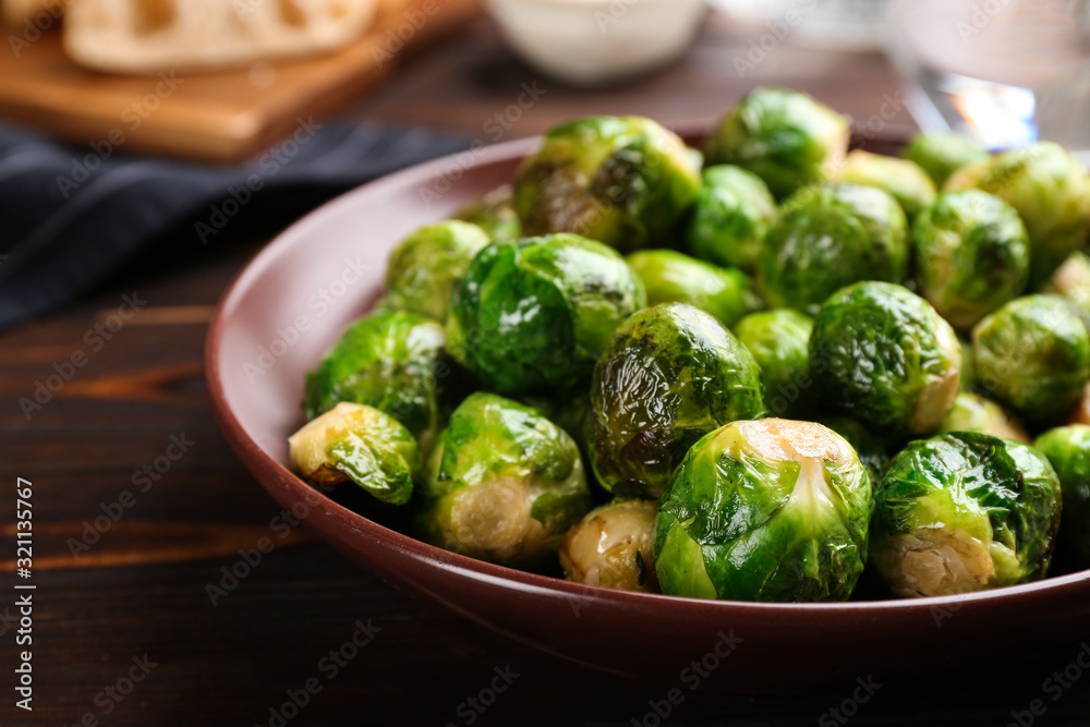 Roasted Brussels sprouts in plate on wooden table Roasted Brussels sprouts in plate on wooden table