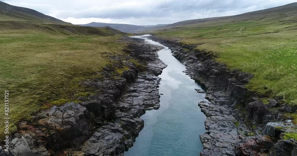 Drone shot of river flowing in mountain against cloudy sky, Hvannalindir, Vatnajokull, Iceland