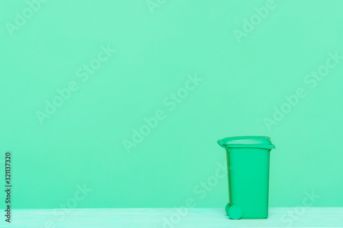 Green recycle bin on green background, great for recycling concepts and designs.
