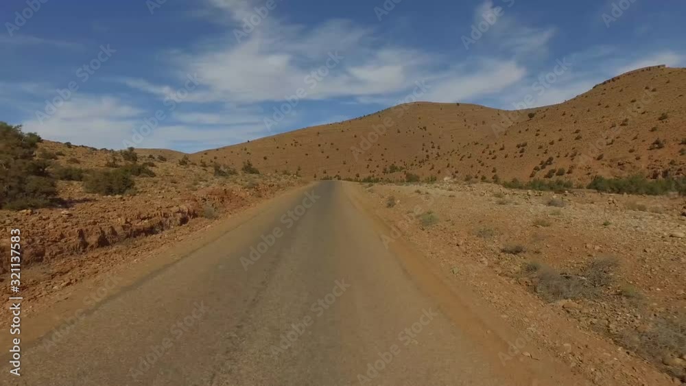 POV shot of empty road by mountain against blue sky, Taghazout, Souss-Massa, Morocco