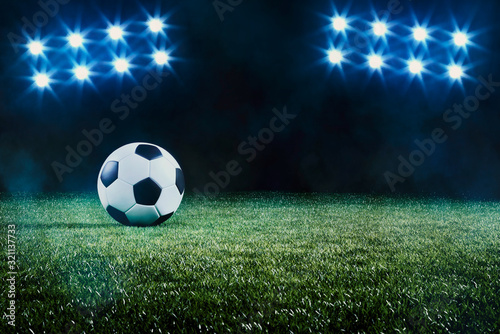 Soccer ball on a grass field backlit by spots © Martin Piechotta
