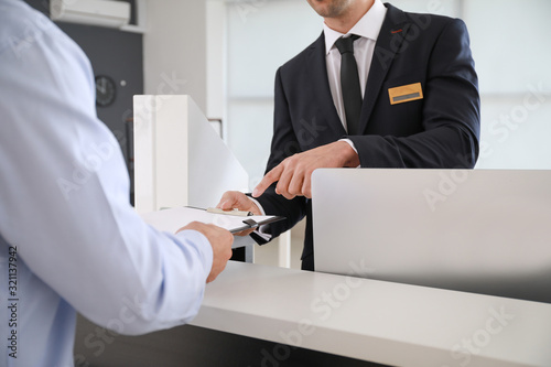Valokuva Male receptionist working with visitor in office