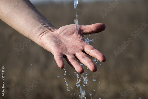 Water flows into the hands of a man