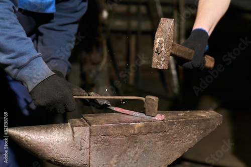 traditional metal forging in a forge with a hammer and chisel