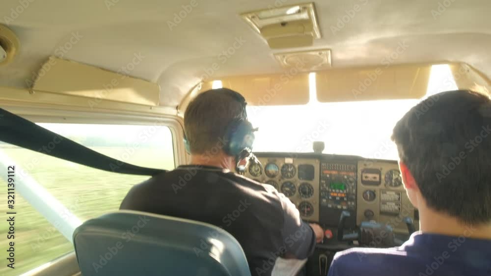 Father and son in propellor plane taking off on sunny runway Father and son in propellor plane taking off on sunny runway