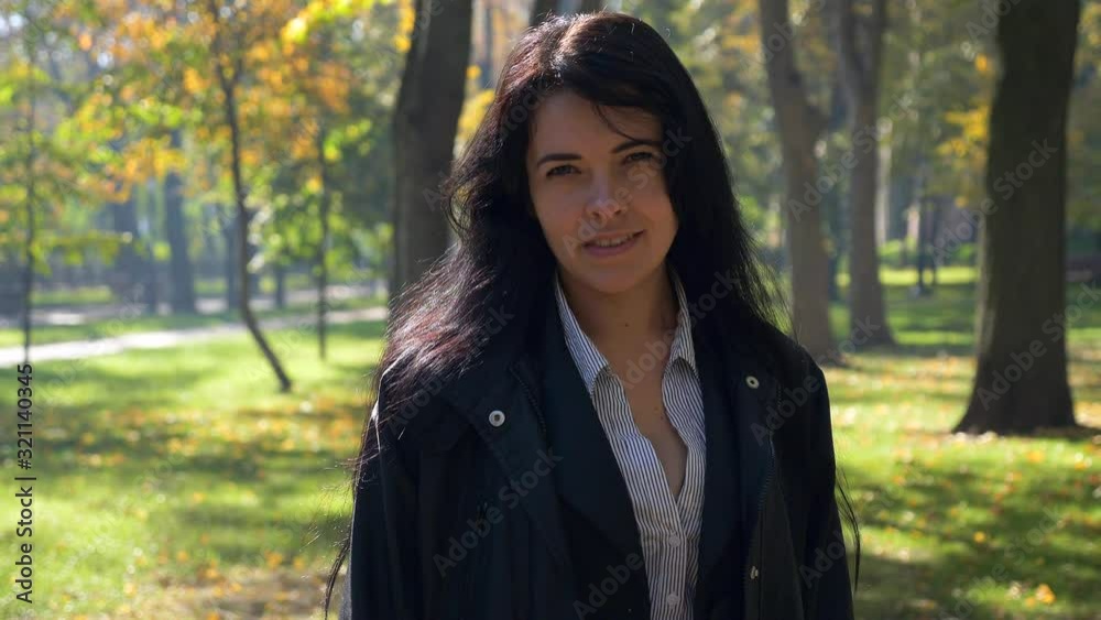 Camera Moves Around Pretty Girl Smiling In City Park. Autumn Sunny Morning. 4K Slow motion 60 fps Camera Moves Around Pretty Girl Smiling In City Park. Autumn Sunny Morning. 4K Slow motion 60 fps