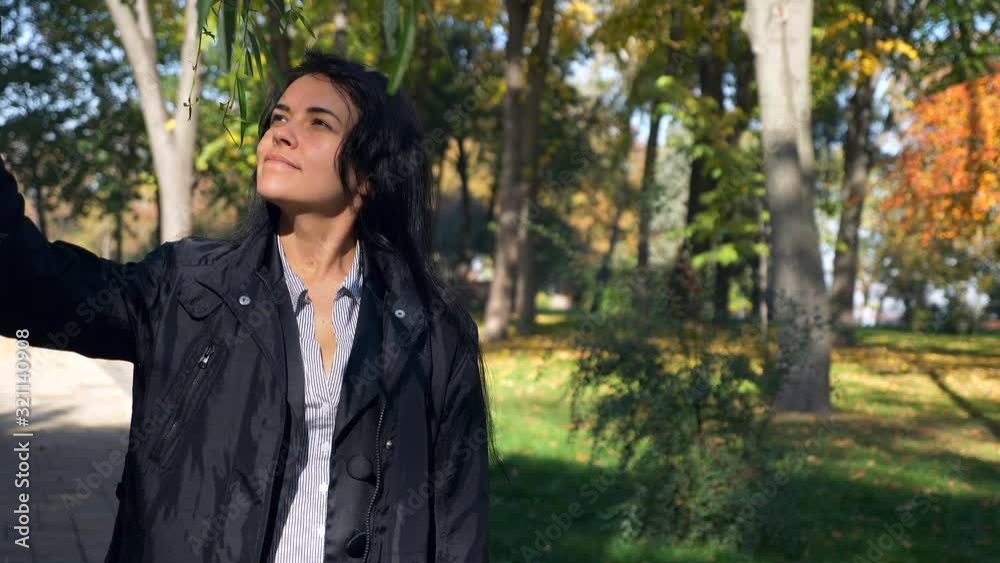 Romantic Pretty Girl Walking In City Park Looking At Trees Leaves. Autumn Sunny Morning. Slow motion 4K 60 fps Romantic Pretty Girl Walking In City Park Looking At Trees Leaves. Autumn Sunny Morning. Slow motion 4K 60 fps