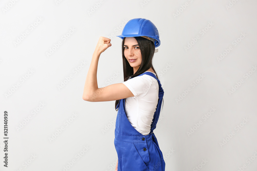 Female worker against light background. Concept of feminism Female worker against light background. Concept of feminism