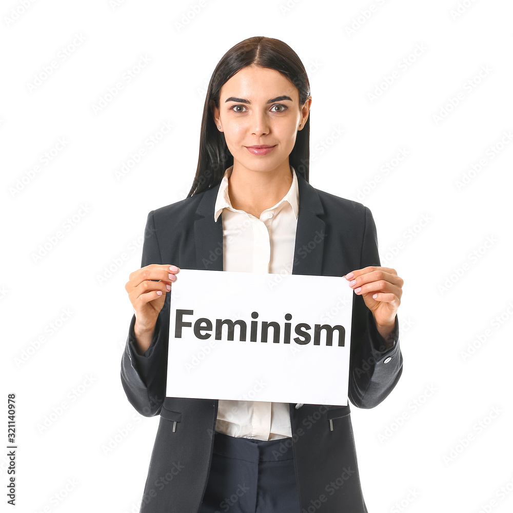 Young businesswoman holding paper with text FEMINISM on white background Young businesswoman holding paper with text FEMINISM on white background