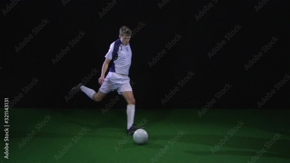 SLO MO, WS, Lockdown, soccer player kicking the ball off camera SLO MO, WS, Lockdown, soccer player kicking the ball off camera