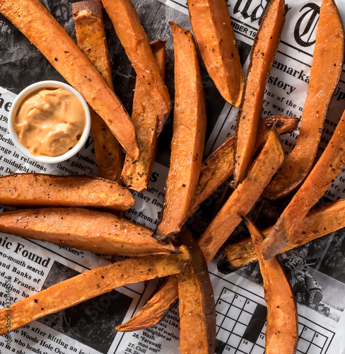 Photography Top down view of a pile of sweet potato fries with habanero aioli for dipping