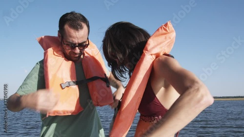 MS, Lockdown of a couple on a boat helping each other put on life jackets