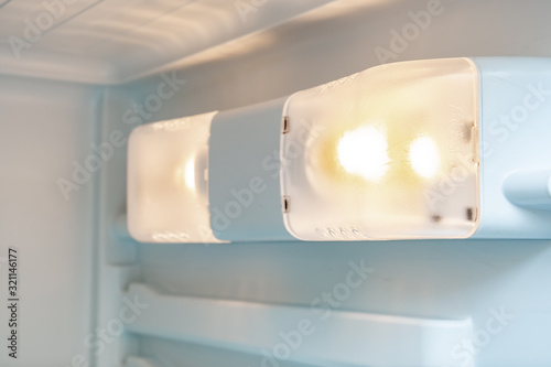 A light inside the fridge, refrigerator close up, a lamp that response to turn on when the door is open, maintenance of home appliances concept, changing the lamp in a freezer