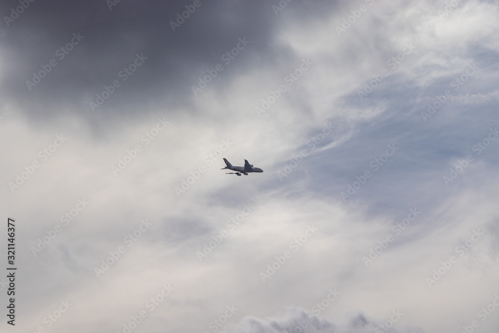 Airplane in the cloudy sky - Passenger Airliner aircraft, London, England