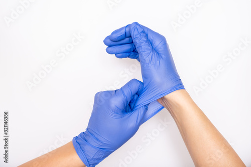Doctor or nurse putting on blue nitrile surgical gloves, professional medical safety and hygiene for surgery and medical exam on white background