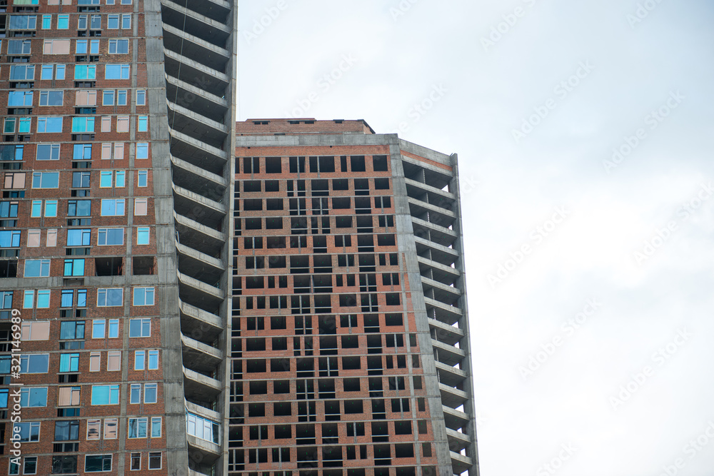 The new high-rise building is an unfinished modern skyscraper in the city center.