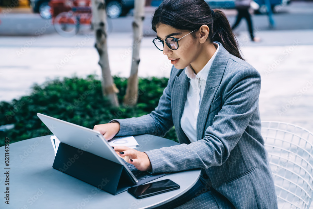 Professional management expert research information on digital tablet while sitting at street cafeteria and messaging with business partners, intelligent woman connected to public 4g internet