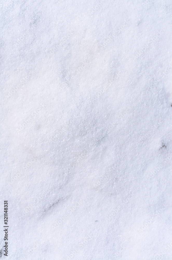 Background of fresh snow white natural texture pattern for minimalistic design in grey tone. Top view witn snowflakes. Concept of abstract winter surface vertical layout with copy space for text.