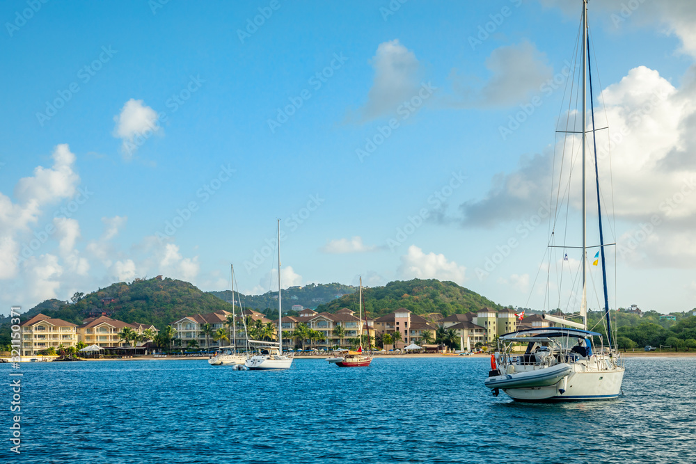 Offshore view of Rodney bay with yachts anchored in the lagoon and rich resorts in the background, Saint Lucia, Caribbean sea