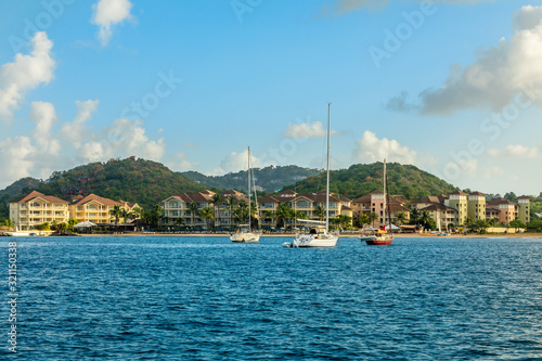Offshore view of Rodney bay with yachts anchored in the lagoon and rich resorts in the background, Saint Lucia, Caribbean sea