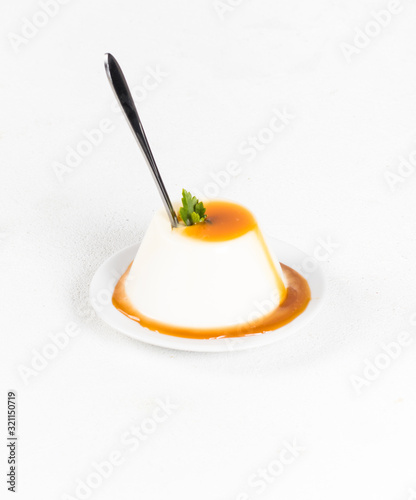 Italian dessert Panna cotta, creamy jelly with caramel sauce on a white background