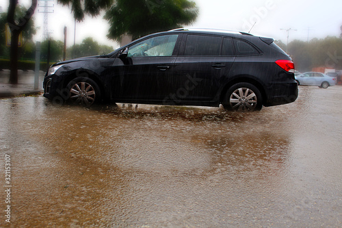 Rain in Israel. The puddle is gradually turning into a flood  rainwater covers the wheels of the car.