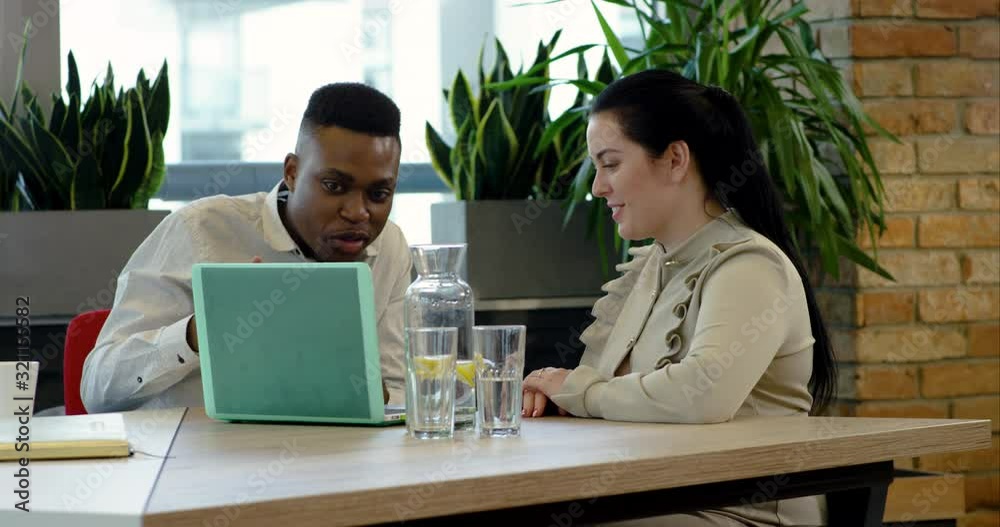 Young Black Office Worker Getting Advice from Disabled Colleague - Wide Dolly Shot (track left)