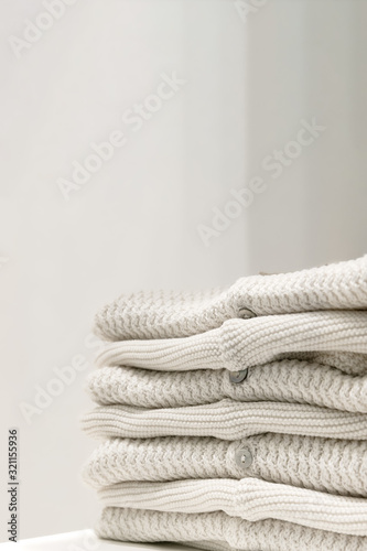 Beige sweaters made from natural fabrics are folded on the table