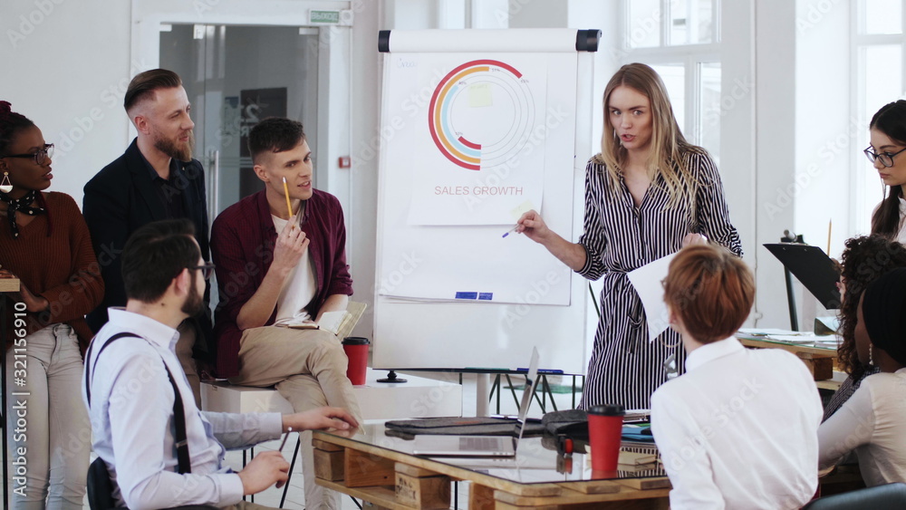 Happy young smiling multiethnic business people applause to young female manager speaking at office table meeting. Happy young smiling multiethnic business people applause to young female manager speaking at office table meeting.
