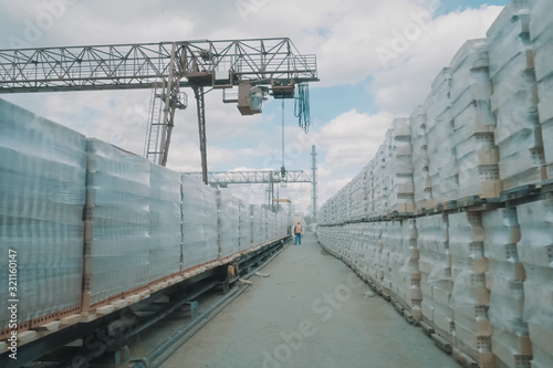 Bricks are stored in an open air warehouse. Red brick in pallets