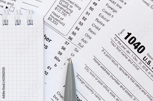 The pen and notebook is lies on the tax form 1040 U.S. Individual Income Tax Return. The time to pay taxes photo