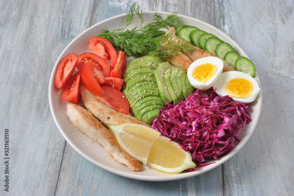 Chicken salad with avocado , tomatoes, red cabbage, cucumbers, boiled eggs and parsley. Healthy lunch bowl with vegetables and chicken on wooden background Healthy food concept Chicken salad with avocado , tomatoes, red cabbage, cucumbers, boiled eggs and parsley. Healthy lunch bowl with vegetables and chicken on wooden background Healthy food concept