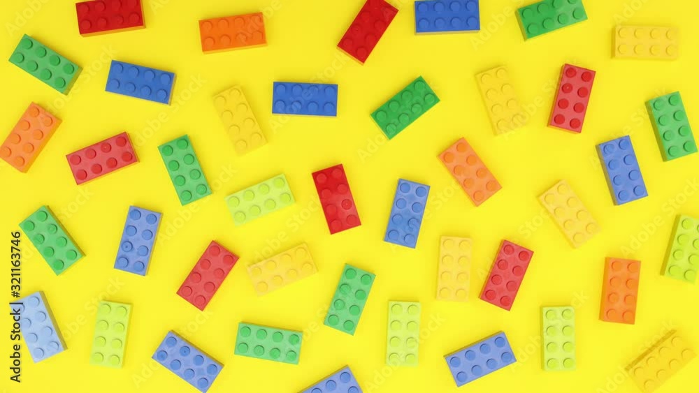 Red, blue, yellow and green bricks blink on yellow background - Stop motion Red, blue, yellow and green bricks blink on yellow background - Stop motion