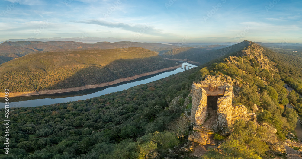 Obraz premium Amazing views during sunset of Extremadura countryfields, its woods and Tajo river from the awesome Monfragûe Castle a great defensive position on a hill with an old Muslim fort in the top of the hill