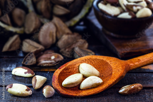 Photo of Brazil nuts, known as castanha-da-amazônia or chestnut-do-acre. Also grown in bolivia. Wooden background, with blur, space for text. known as "castanha do pará".