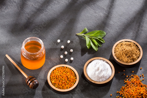 Tableau sur toile Variety of natural sweeteners - Pollen, honey, sugar and stevia leaves