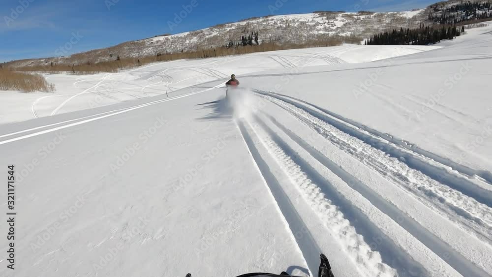 Snowmobile follow rider high mountain in winter POV. Snowmobile trail ride across high mountain meadow and forest at high speed in central Utah in winter. Recreation and fun Snowmobile follow rider high mountain in winter POV. Snowmobile trail ride across high mountain meadow and forest at high speed in central Utah in winter. Recreation and fun