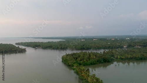 Beautiful aerial shot of a backwater Vembanadu Lake , sunset,coconut trees,clouds,water lines,twilight photo